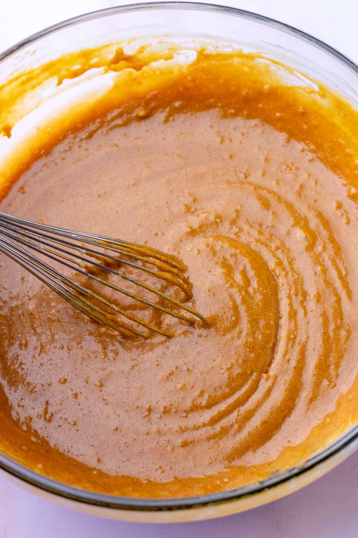 Whisking wet ingredients in bowl for Sourdough ginger molasses cookies
