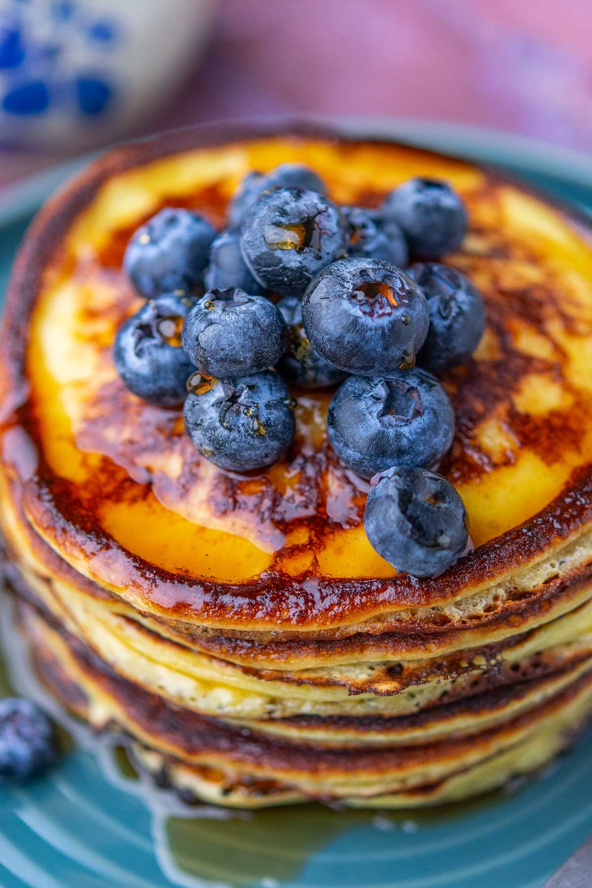 Blueberries on top of a stack of sourdough cottage cheese protein pancakes.