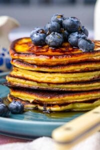 Stack of sourdough cottage cheese protein pancakes with blueberries and maple syrup.