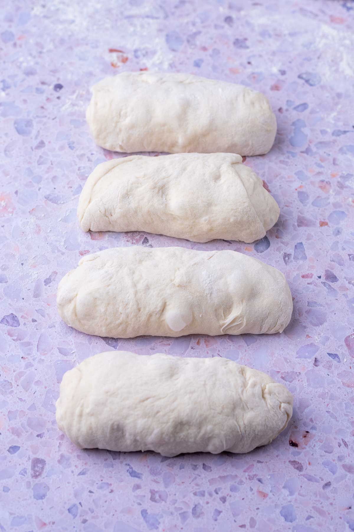 Four preshaped sourdough baguettes.