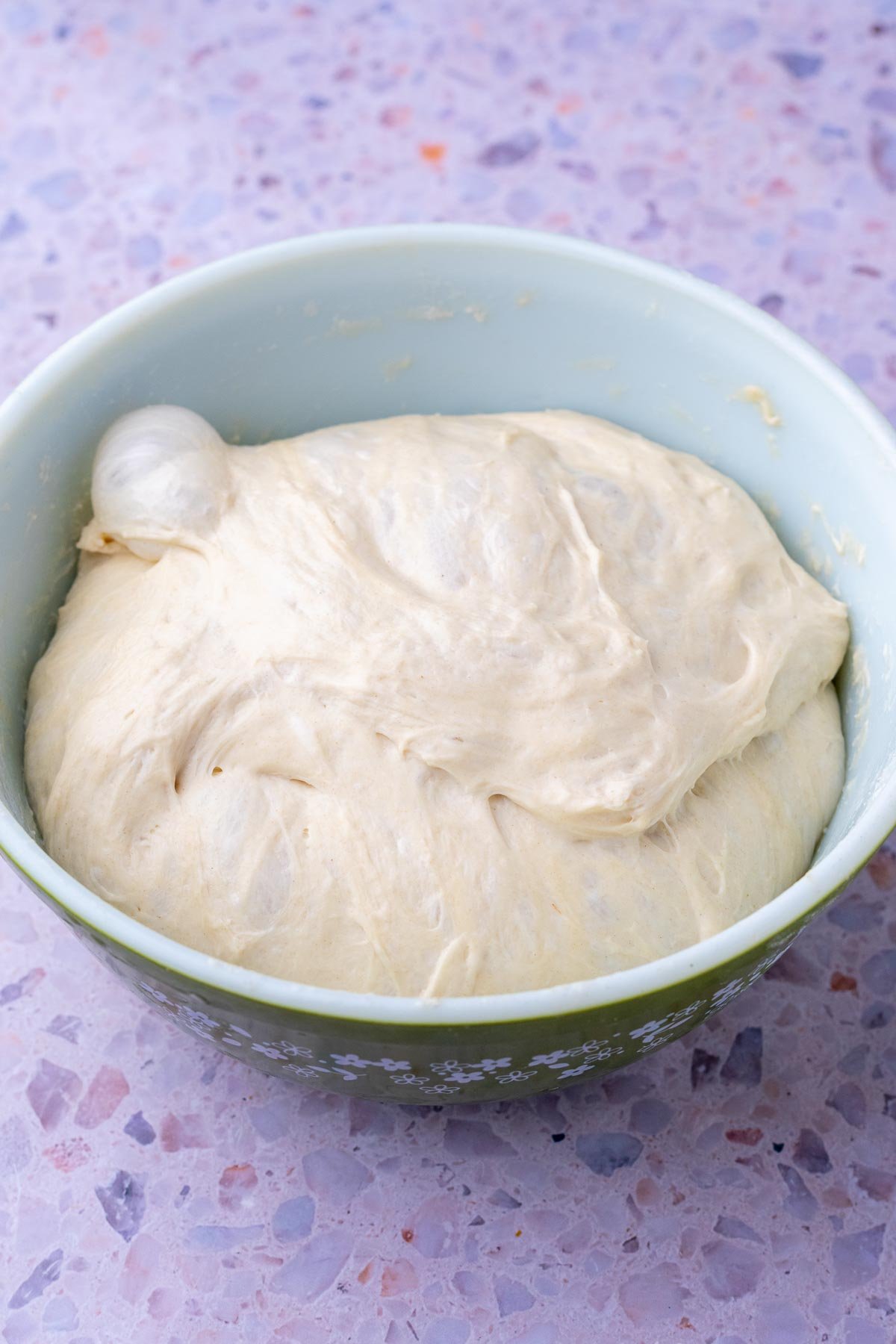 Sourdough baguette dough doubled in size in a bowl at the end of bulk fermentation