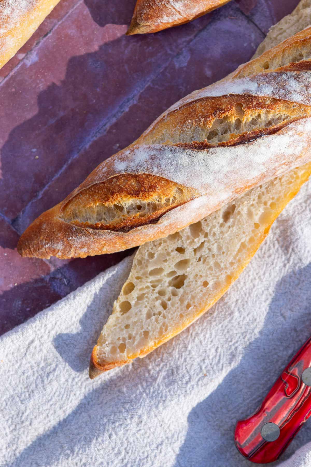 Close up of sliced sourdough baguette and crumb.
