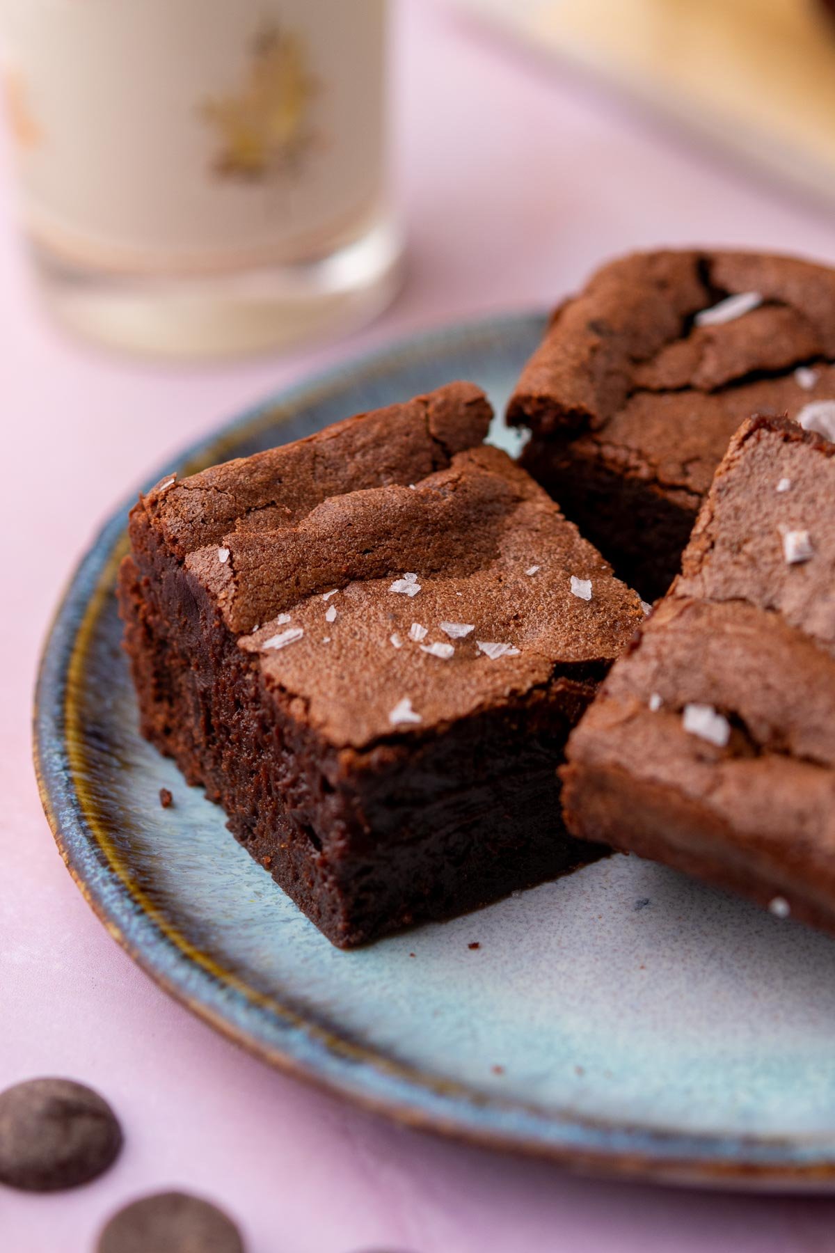 Sliced fudgy sourdough brownies on a plate with a glass of milk in the background.