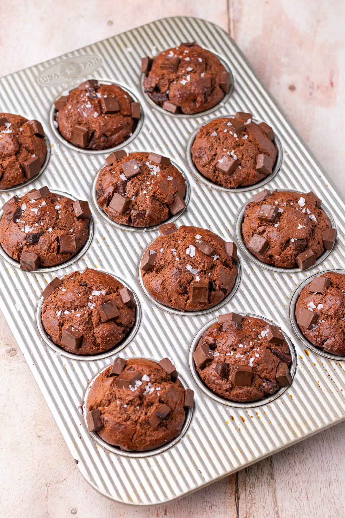 Baked sourdough chocolate muffins in a muffin pan.