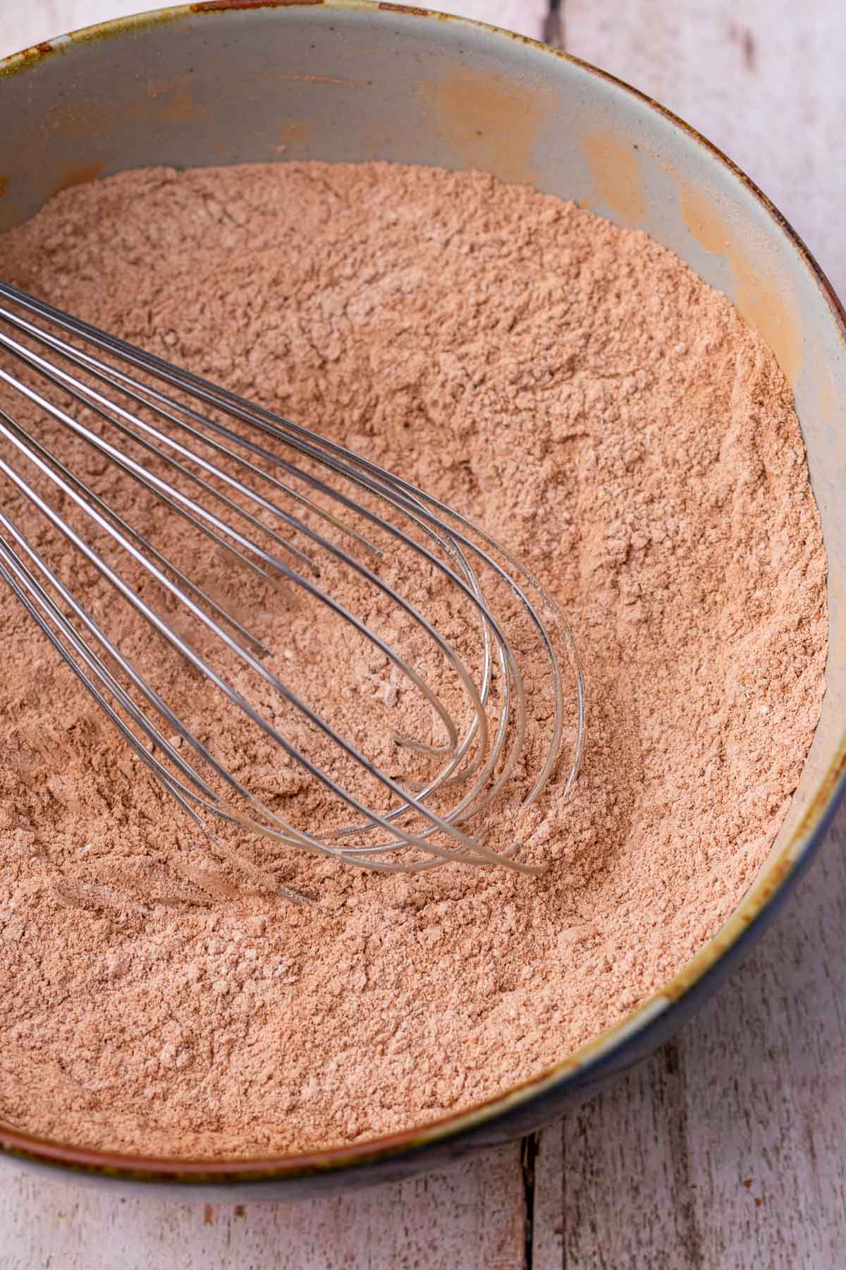 bowl with dry ingredients for sourdough chocolate muffins and a whisk. 