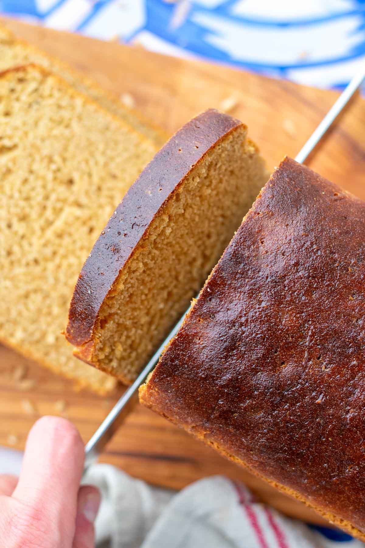 Slicing einkorn sourdough sandwich bread with a bread knife.