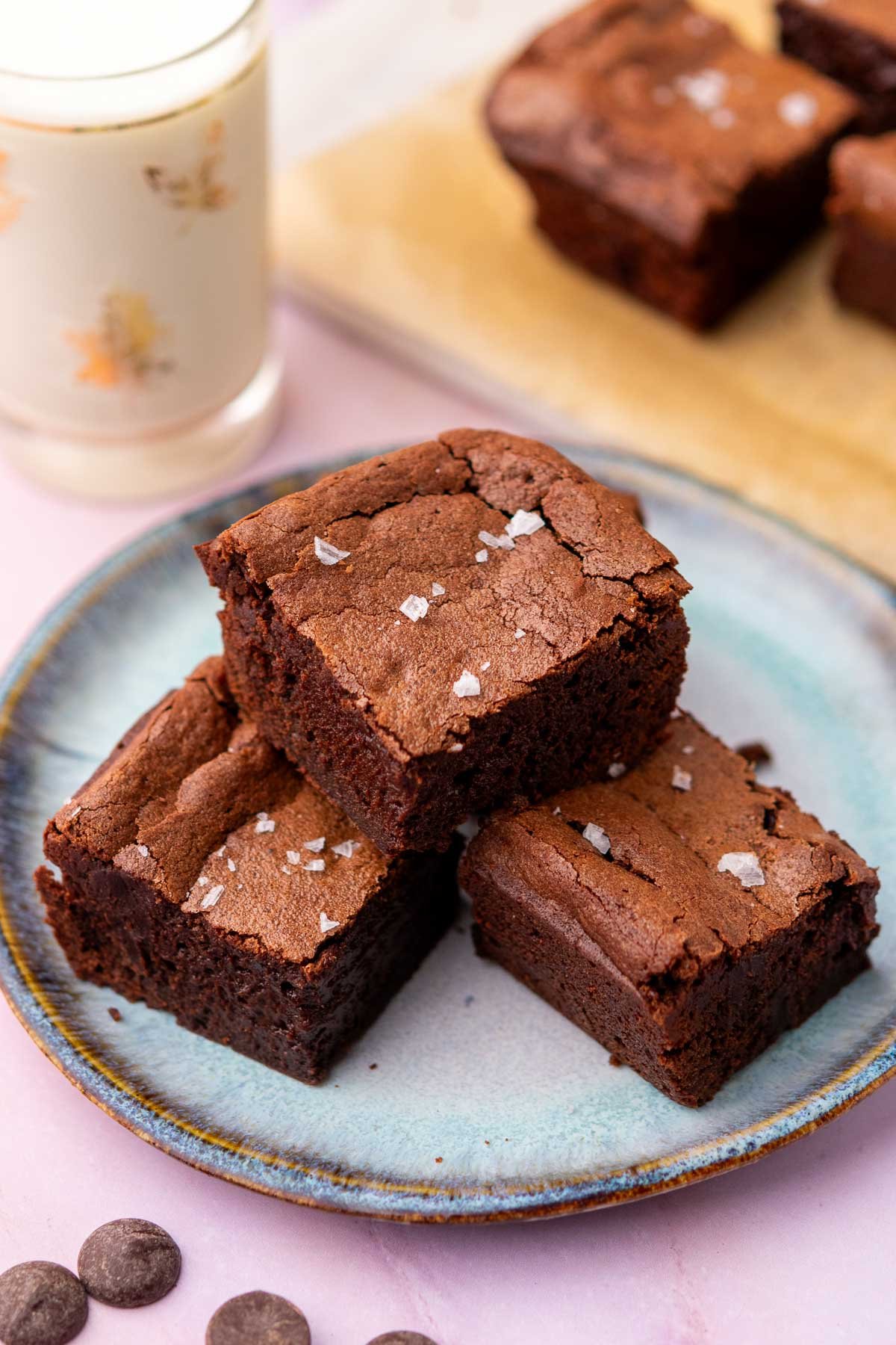 Plate with fudgy sourdough discard brownies with a glass of milk in the background.