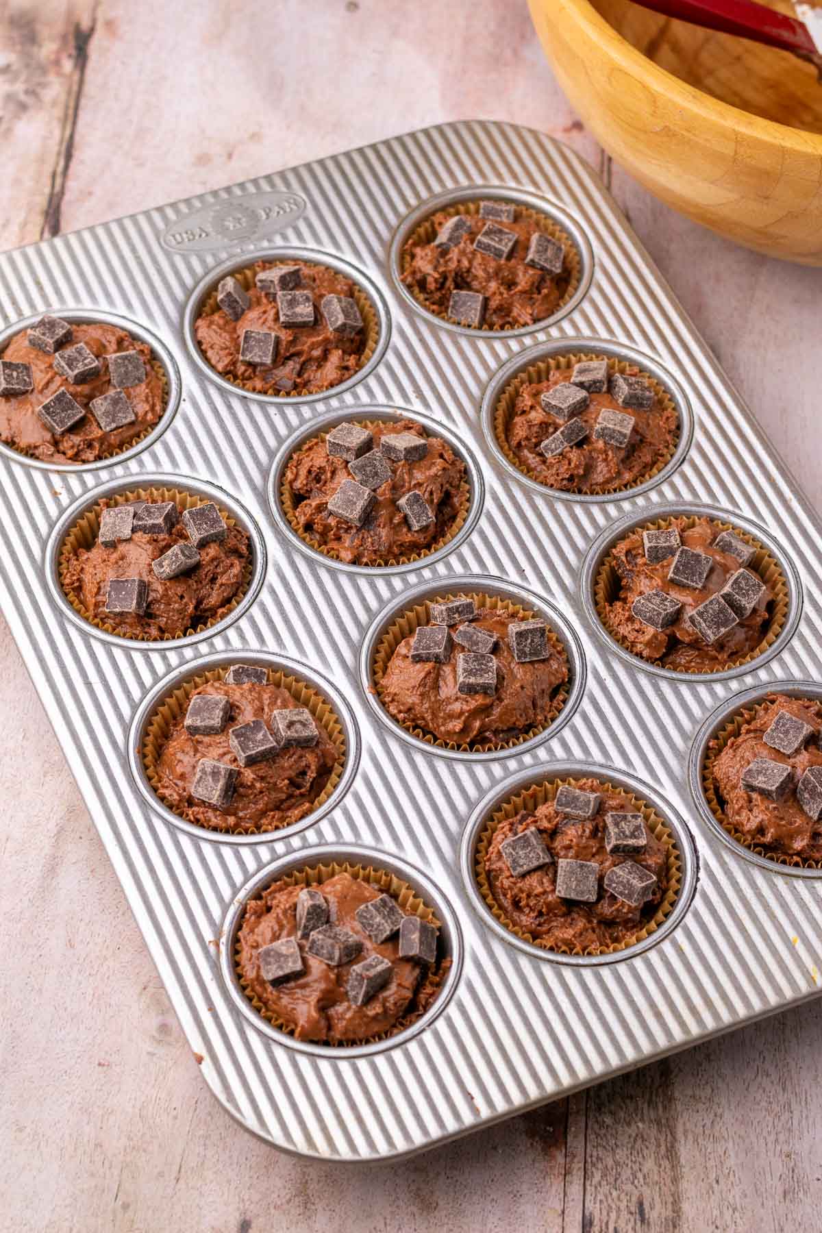 Unbaked sourdough double chocolate muffins in a muffin pan. 