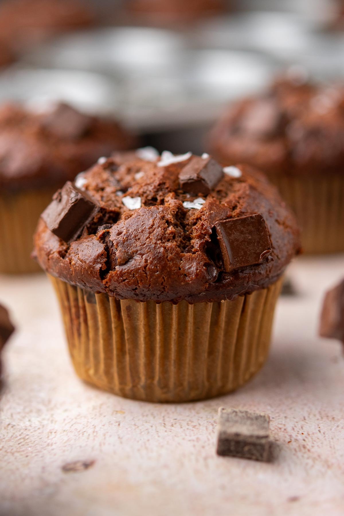 A sourdough discard chocolate muffin with chocolate chunks and flaky salt.