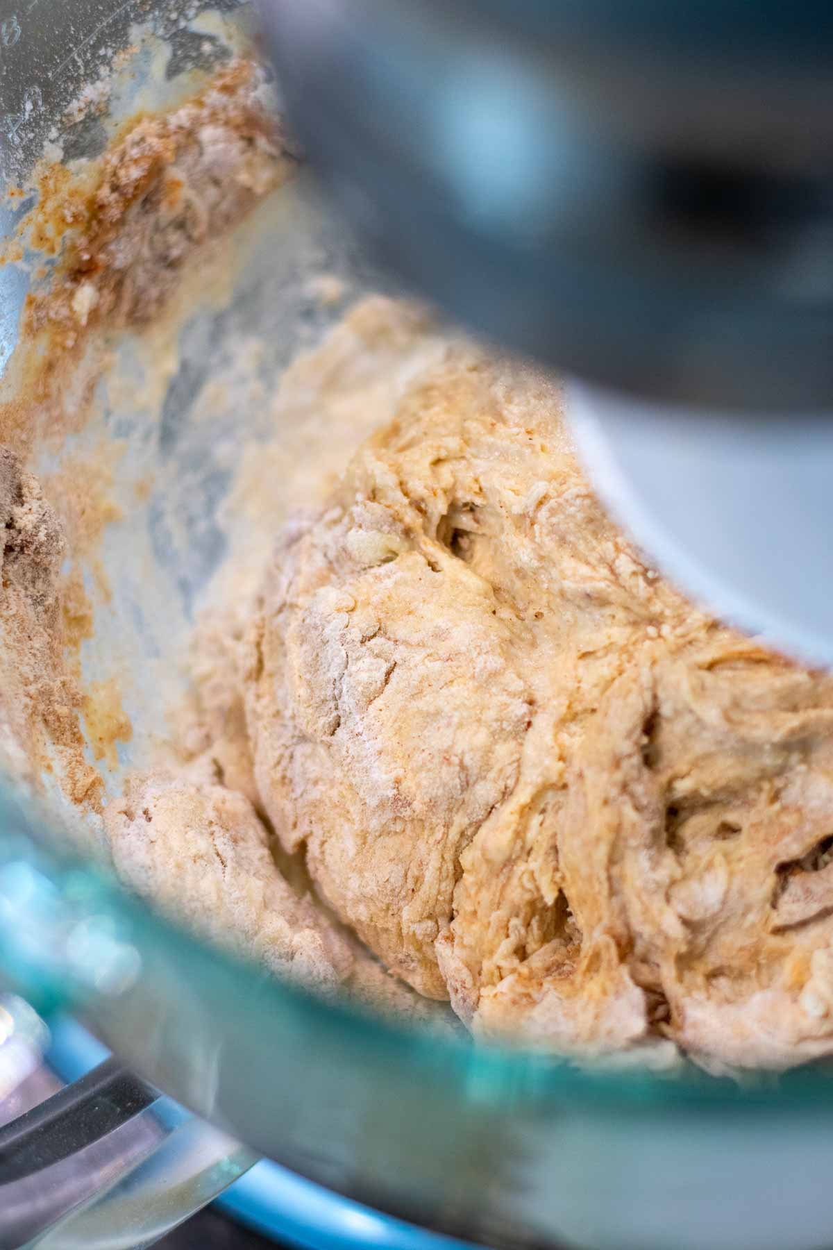 Mixing sourdough cinnamon raisin english muffin dough in a stand mixer with a dough hook.