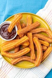 Sourdough Churros on a plate with cinnamon sugar and chocolate dipping sauce