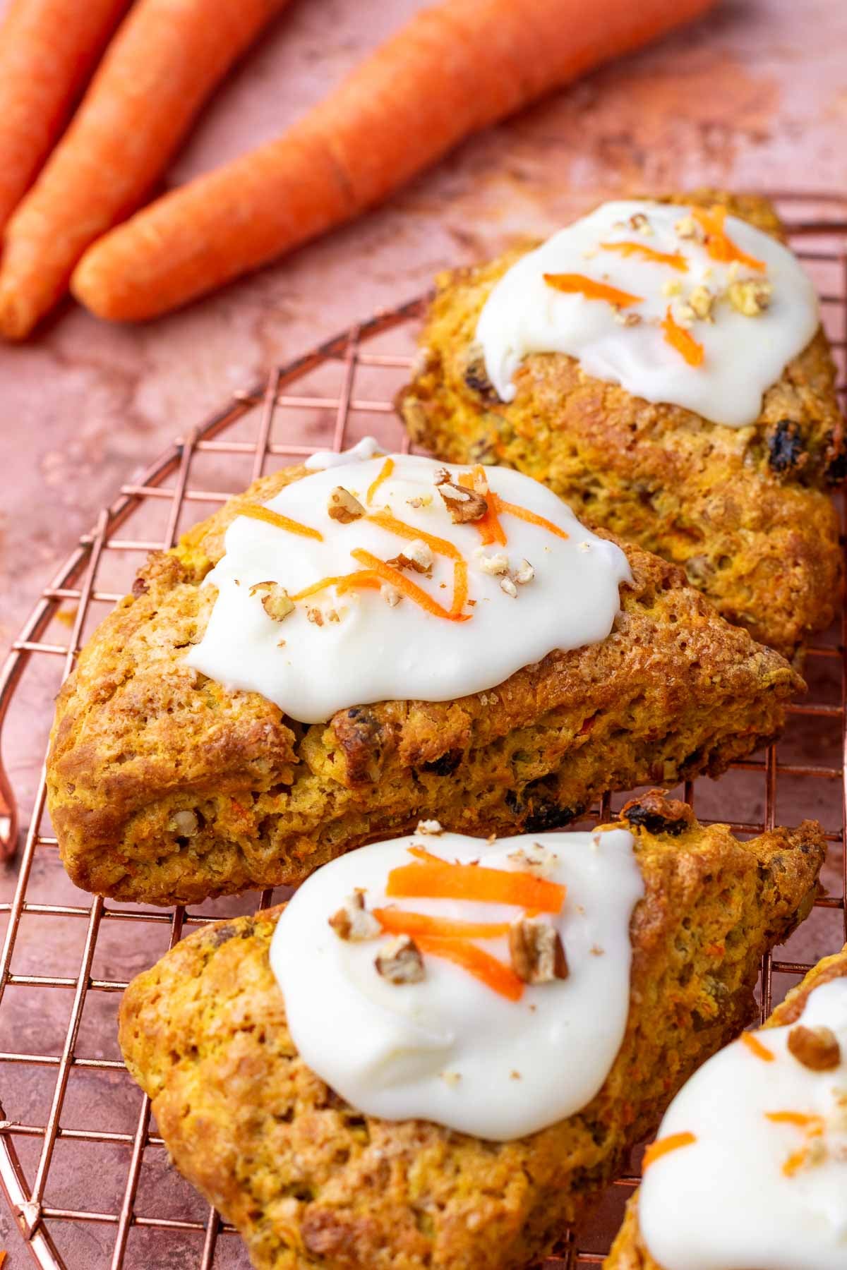 Sourdough carrot cake scones on a wire rack with cream cheese glaze.