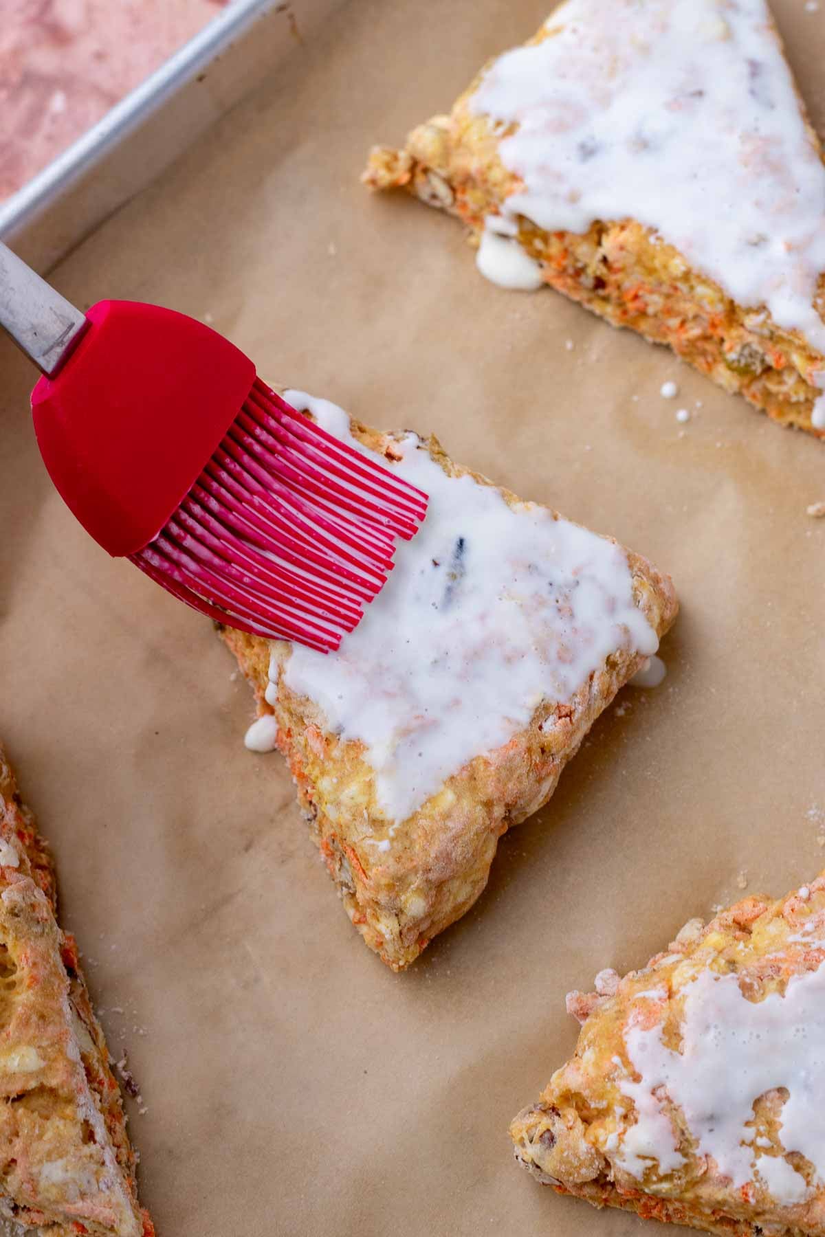 Brushing cream on sourdough carrot cake scones.