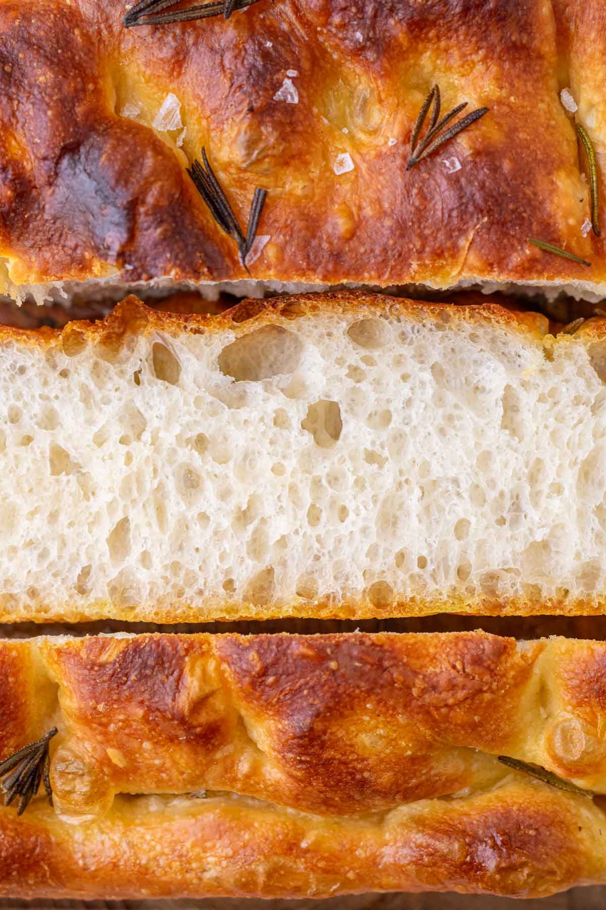 Close up of sliced sourdough focaccia with open crumb.