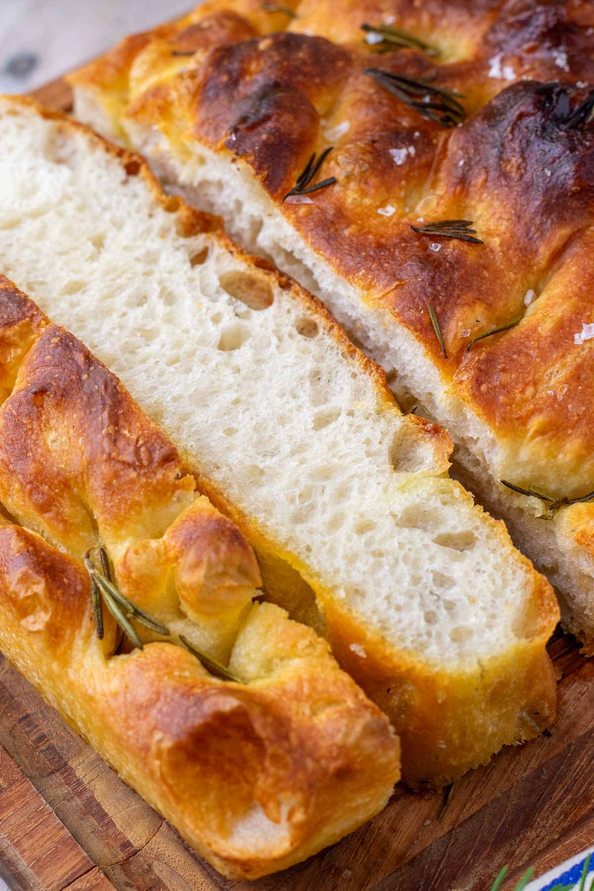 Sliced sourdough focaccia on a cutting board.