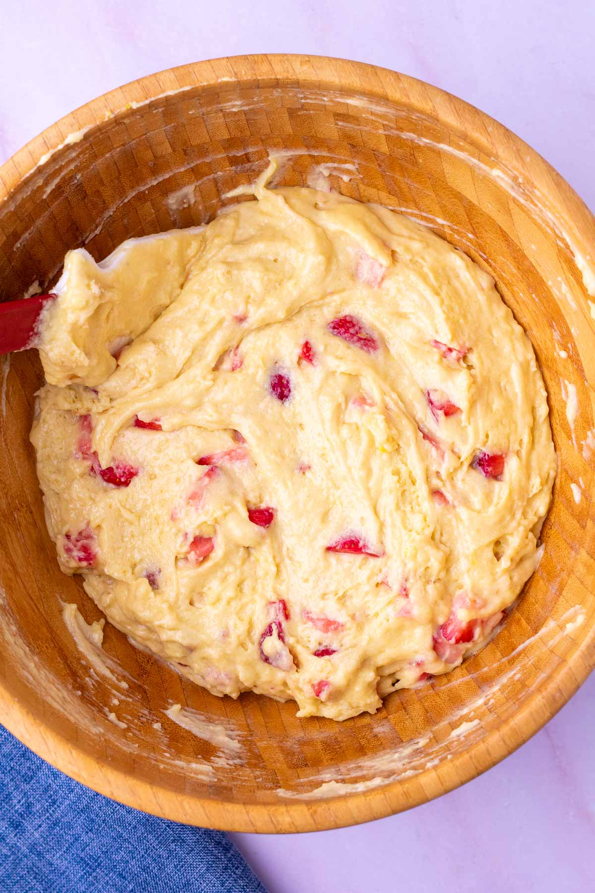 Mixed Sourdough strawberry muffin batter in large wooden bowl with a spautla.