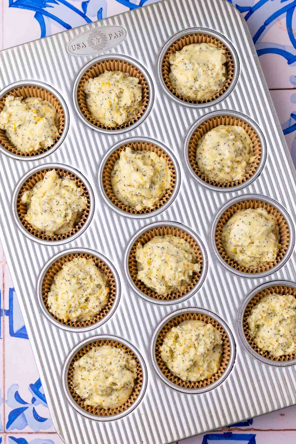 Unbaked sourdough lemon poppy seed muffins in muffin pan.