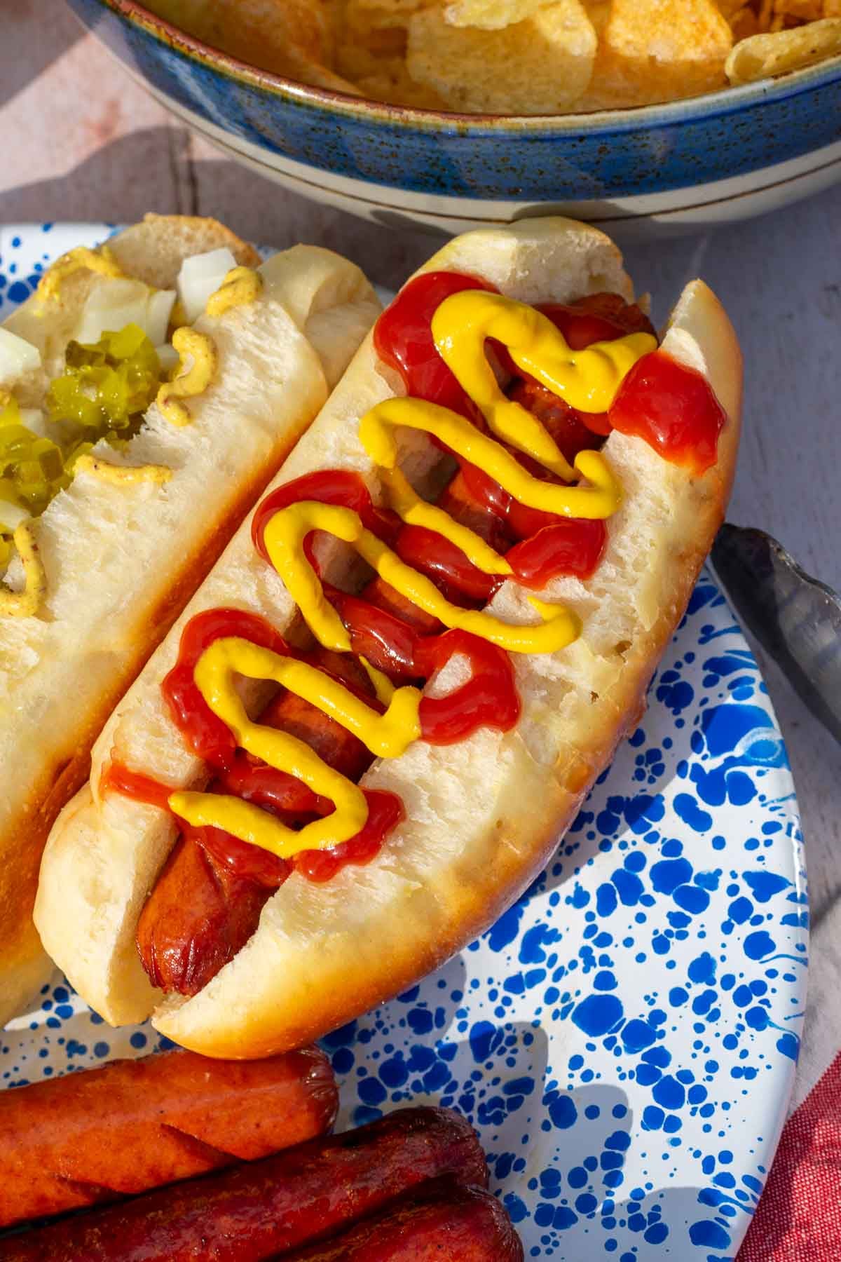 Hot Dog with ketchup and mustard in a sourdough hot dog bun on a plate.