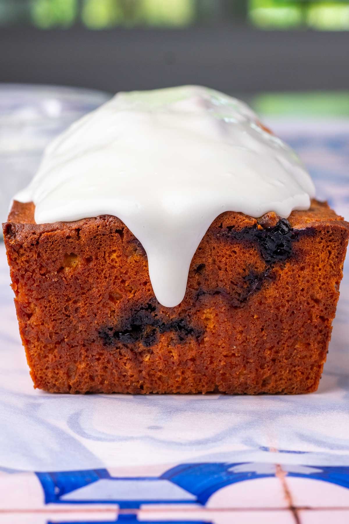Glaze dripping on side of lemon blueberry sourdough pound cake.