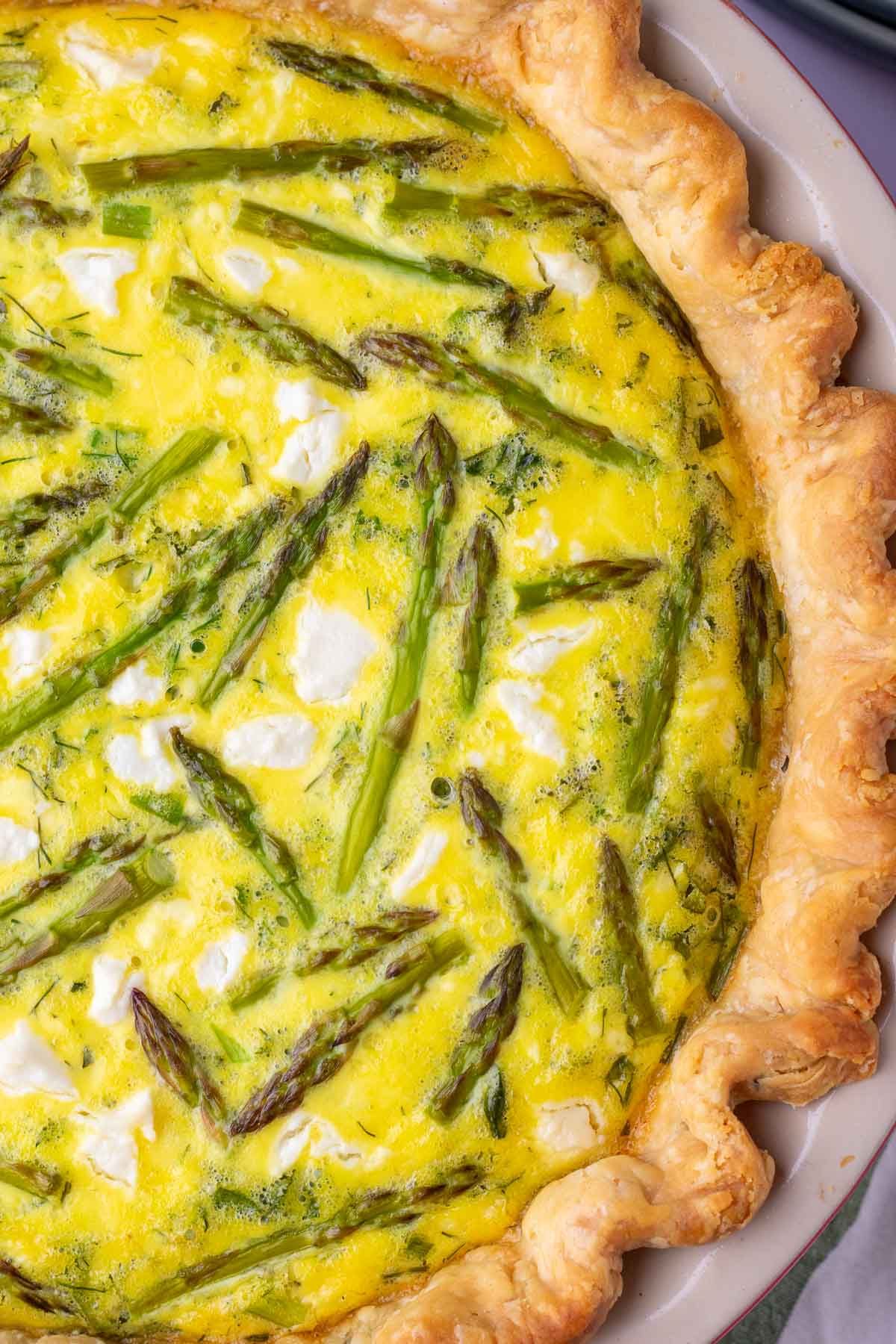 Close up image of asparagus goat cheese sourdough quiche.