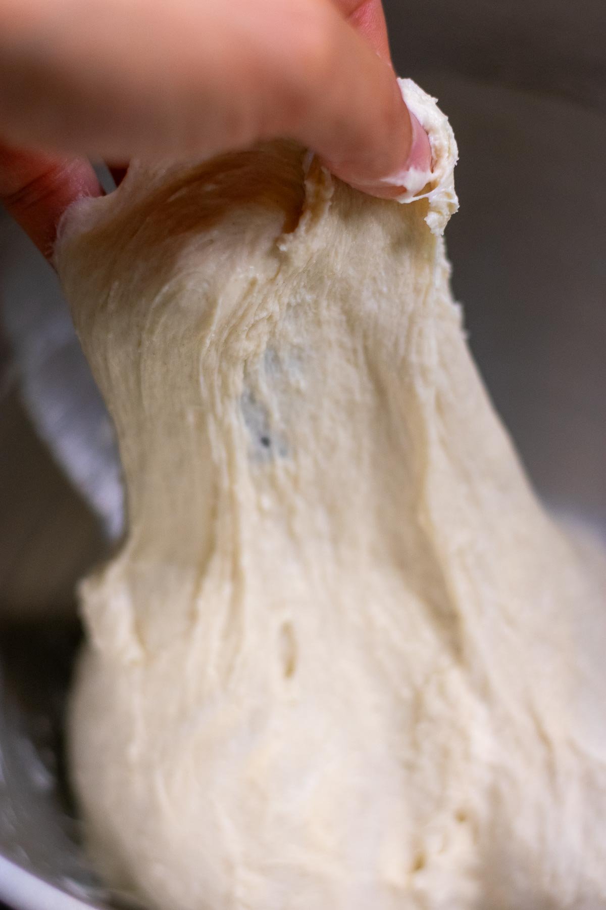 Hand stretching mixed sourdough pita bread dough.
