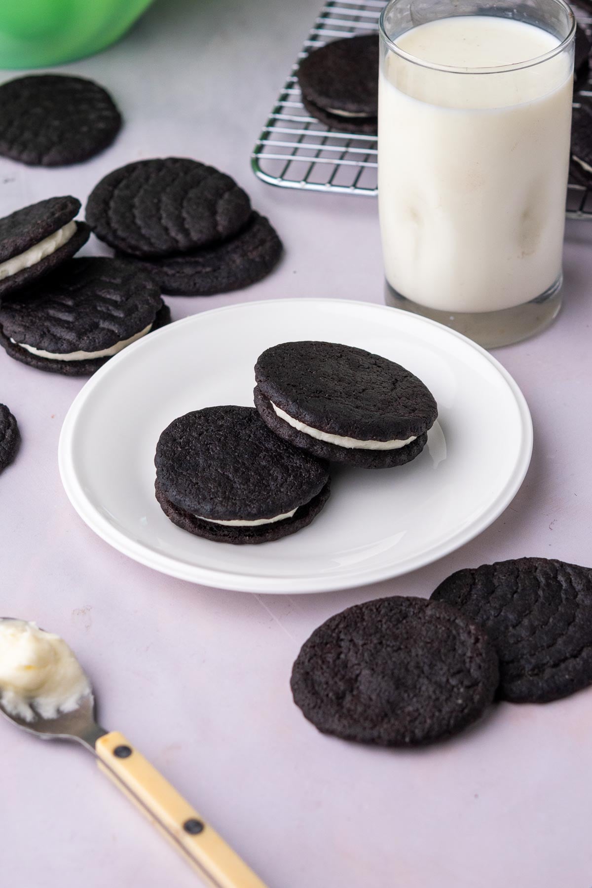 Sourdough oreos on a plate with a glass of milk.