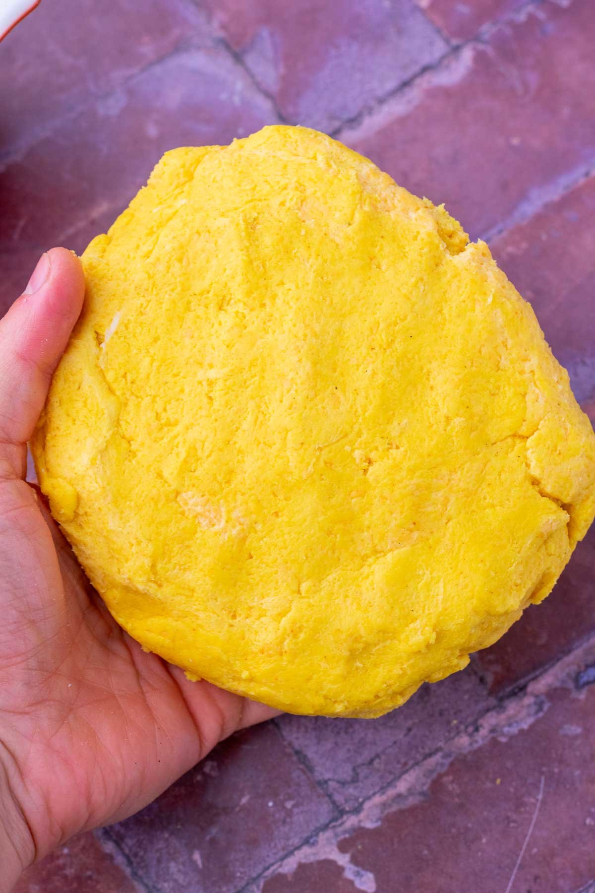 Hand holding Sourdough discard cheese crackers dough.