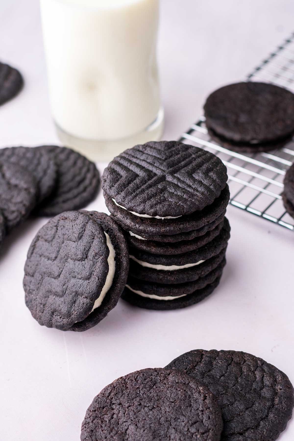 Stack of sourdough oreos with a glass of milk in the background.