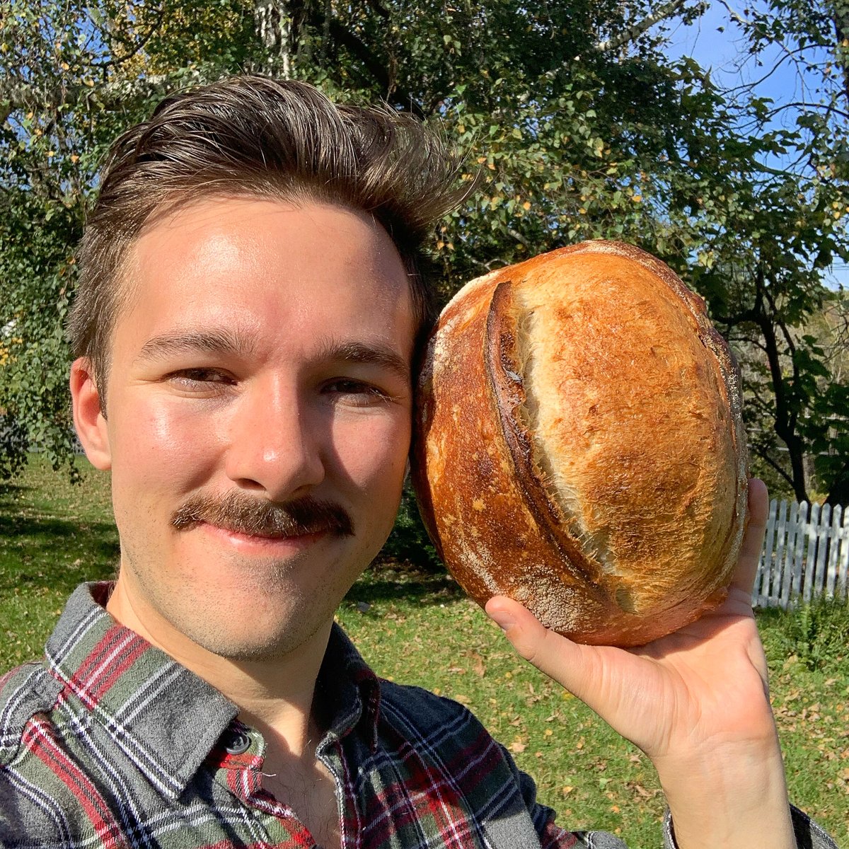 Sourdough Brandon holding a loaf of bread.