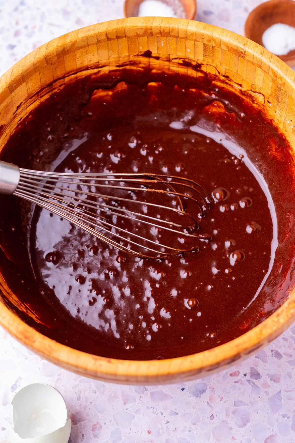 Whisk in bowl mixing sourdough pumpkin brownie batter.