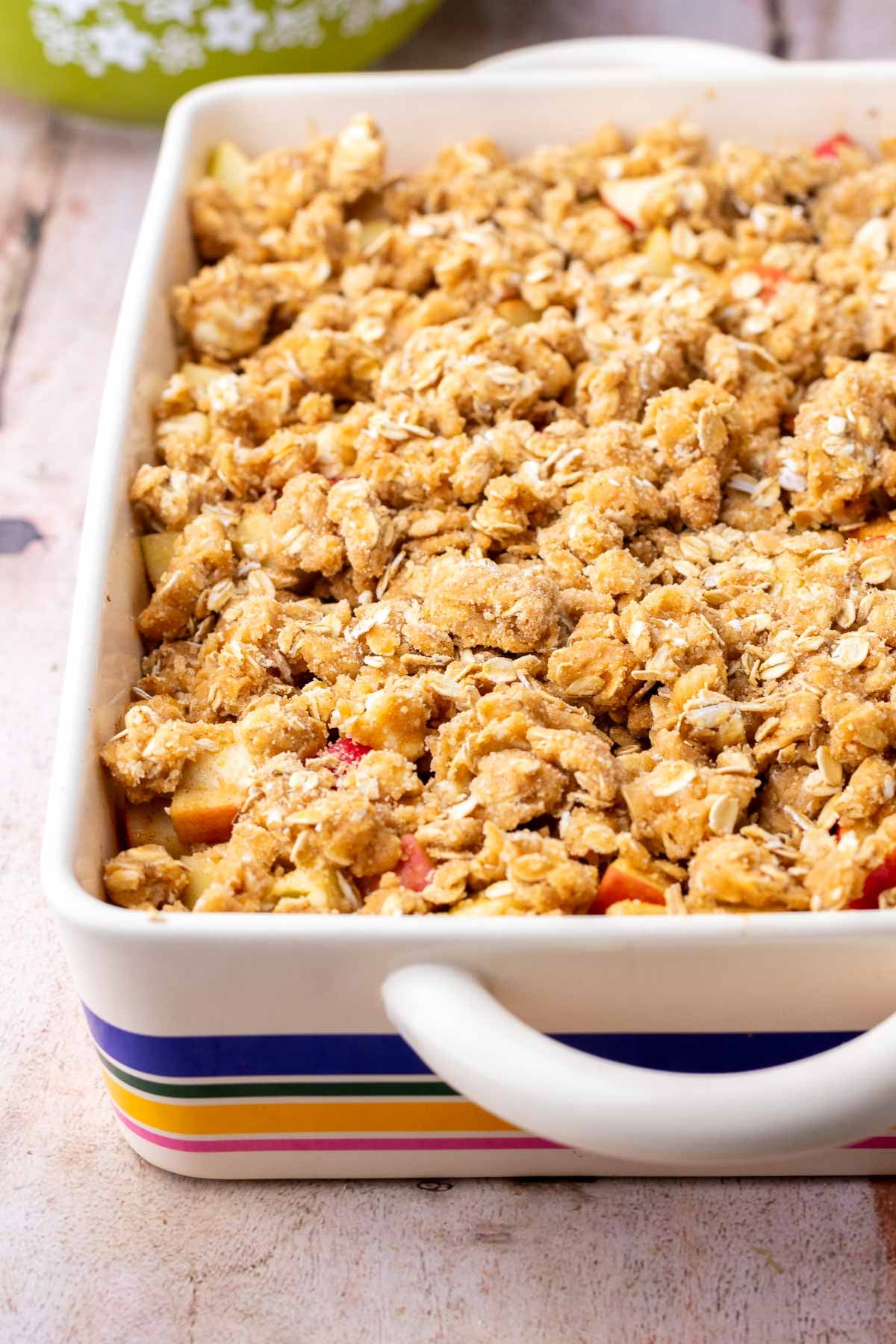 Unbaked sourdough apple crisp in baking dish with streusel topping.