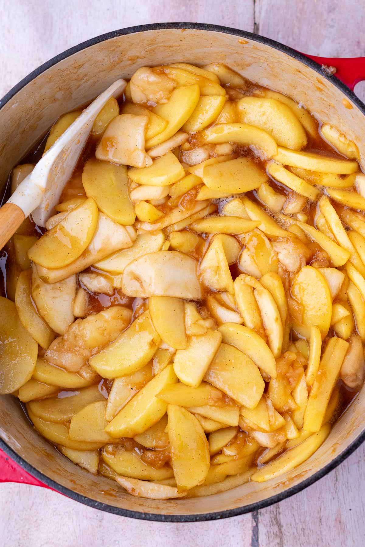 Cooked sourdough apple pie filling in a pot with a spatula.