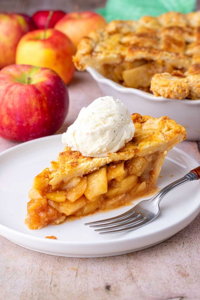 Perfect slice of sourdough apple pie with a scoop of ice cream on a plate with a fork.