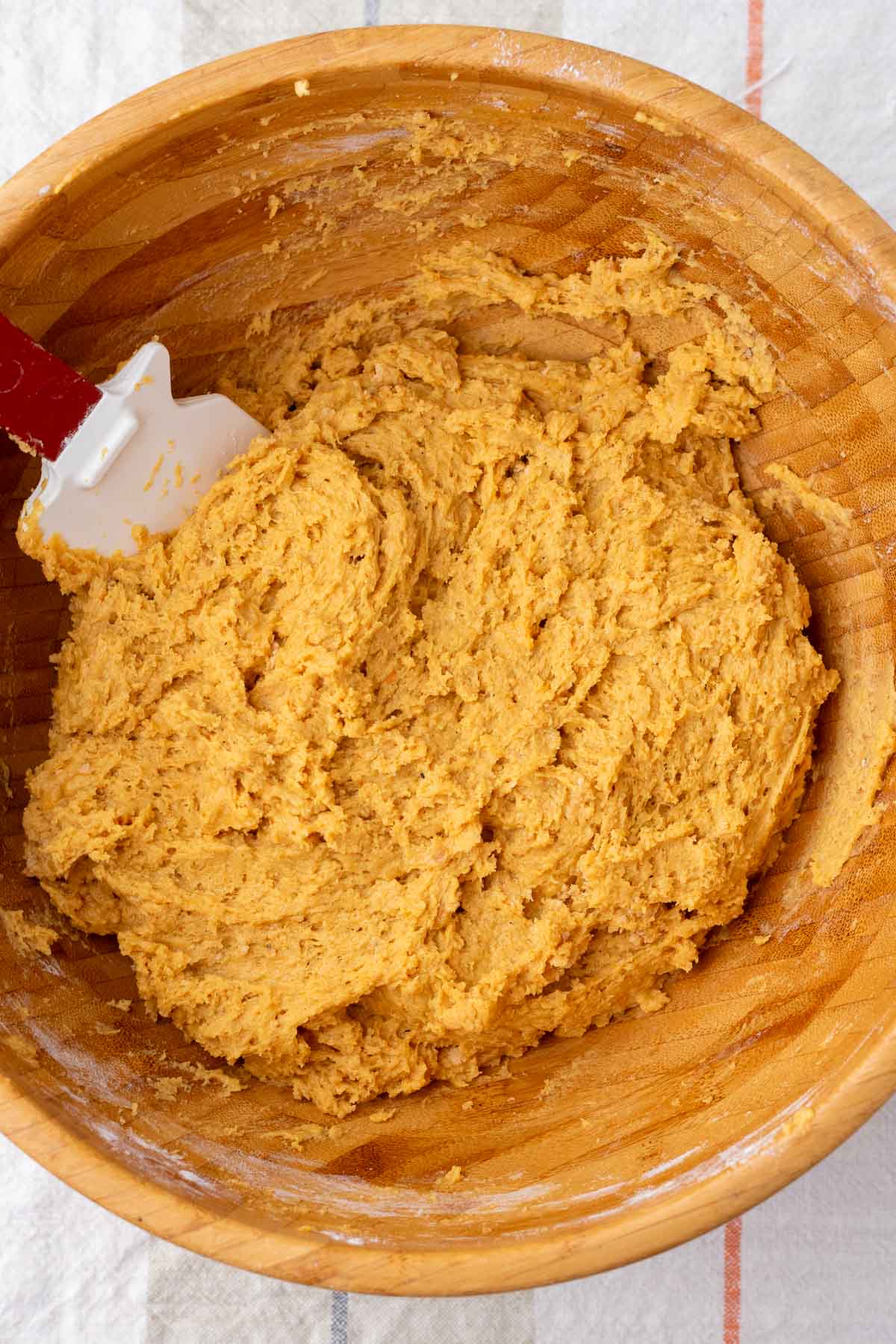 Mixed sourdough pumpkin donut batter in a large bowl with a spatula.