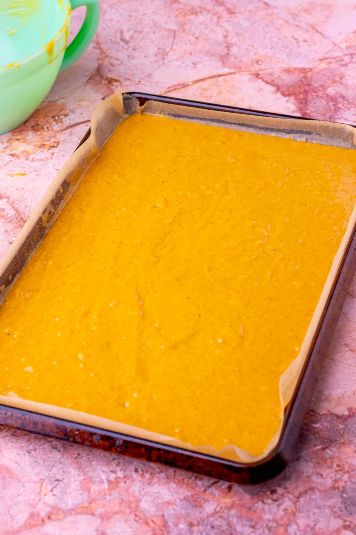 Unbaked sourdough pumpkin roll batter on a sheet pan.