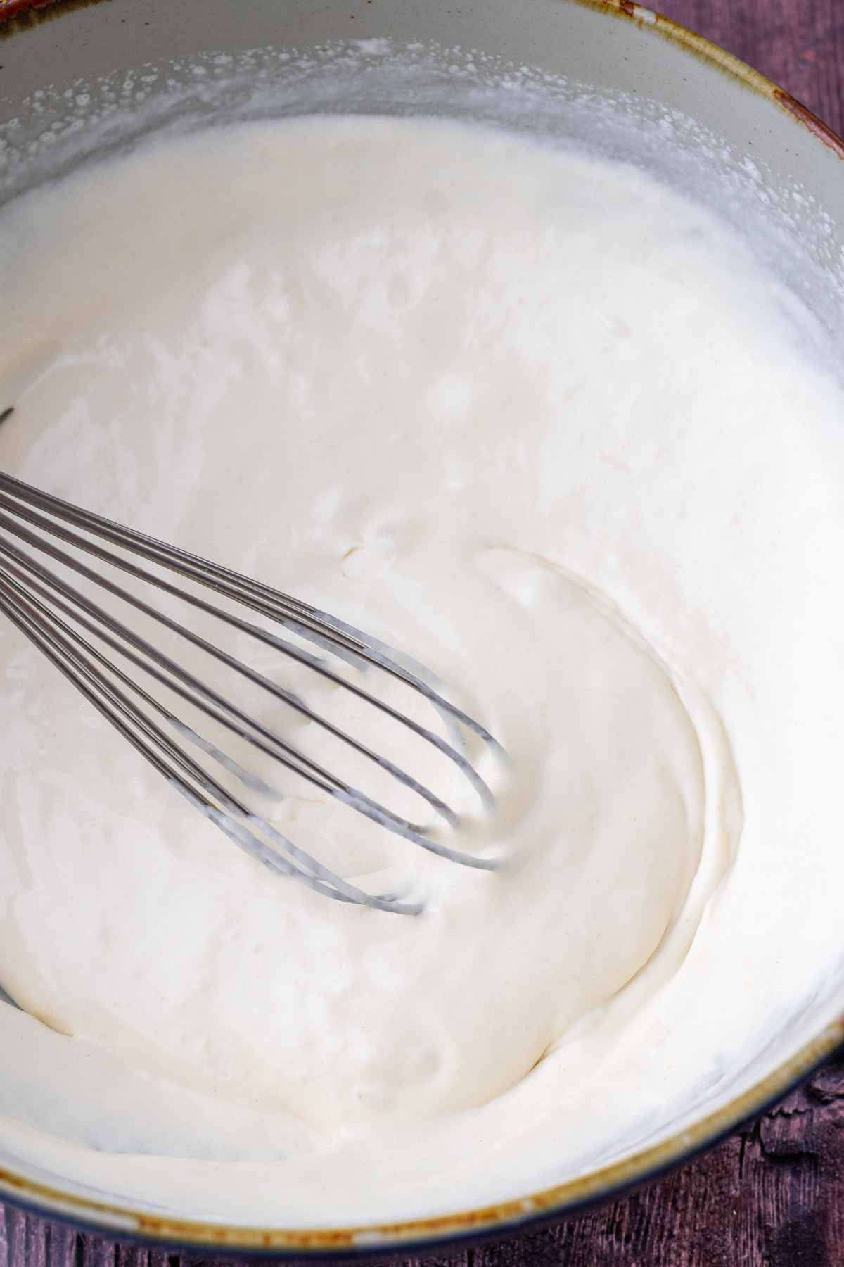 Whisk mixing wet ingredients for sourdough maple pecan scones.