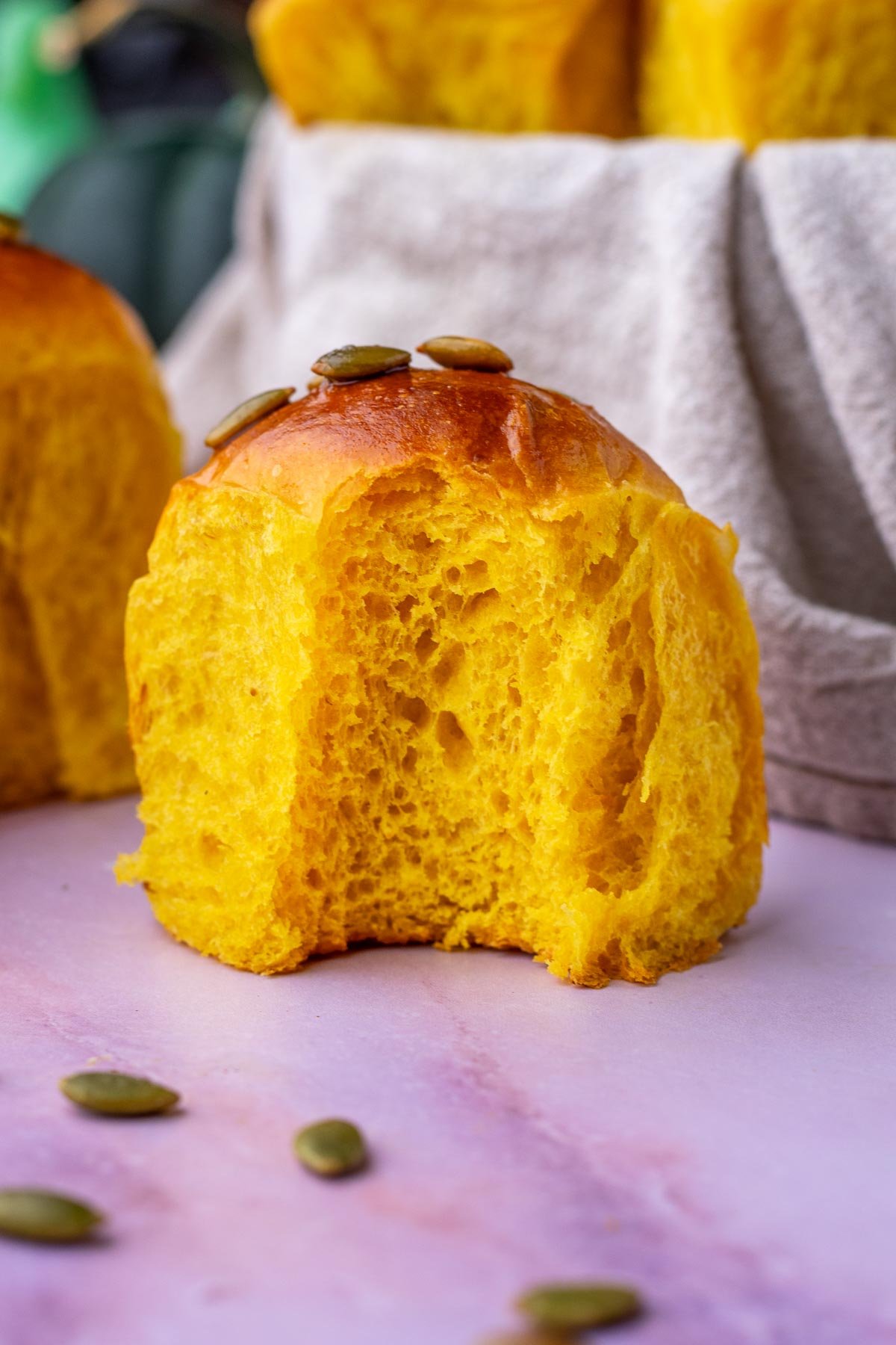 Bite taken out of a sourdough pumpkin dinner roll.