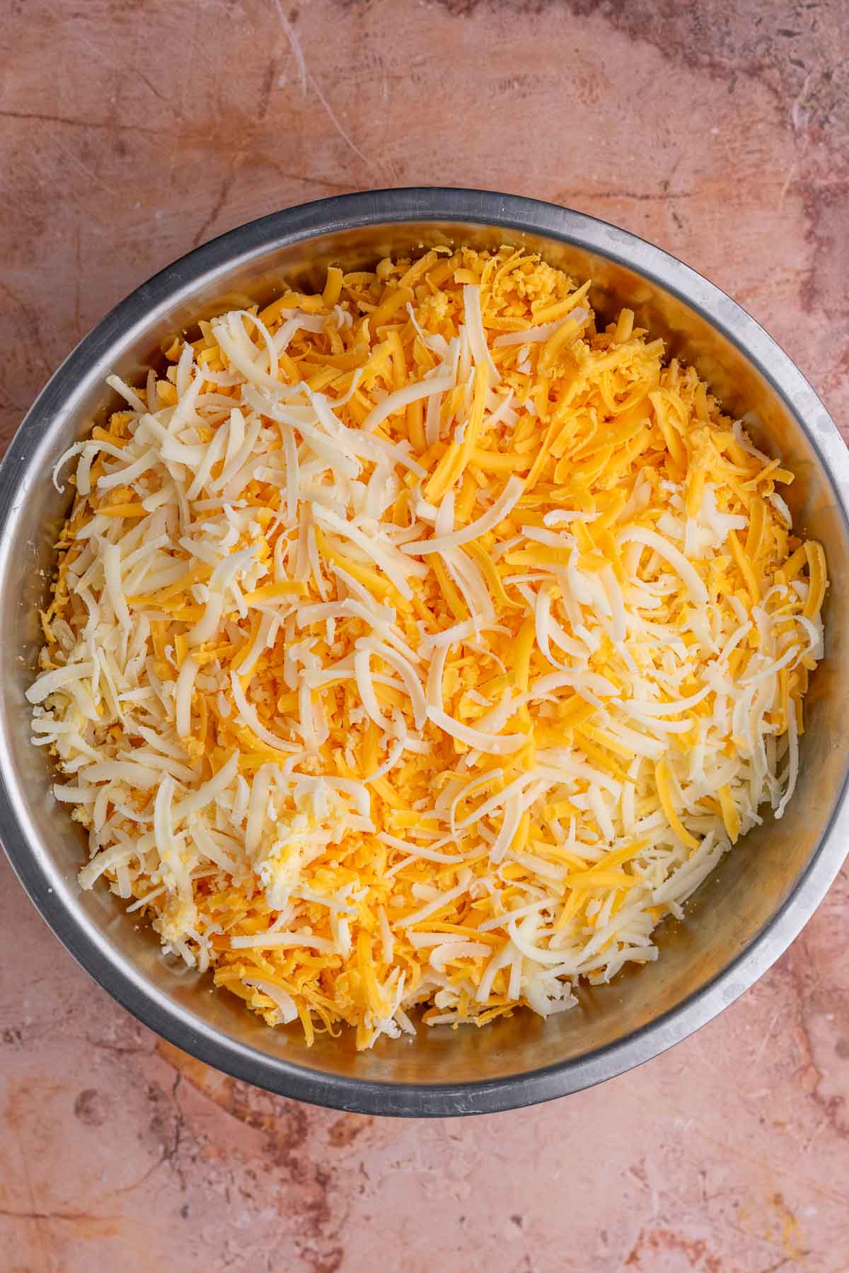 Bowl of shredded cheeses.