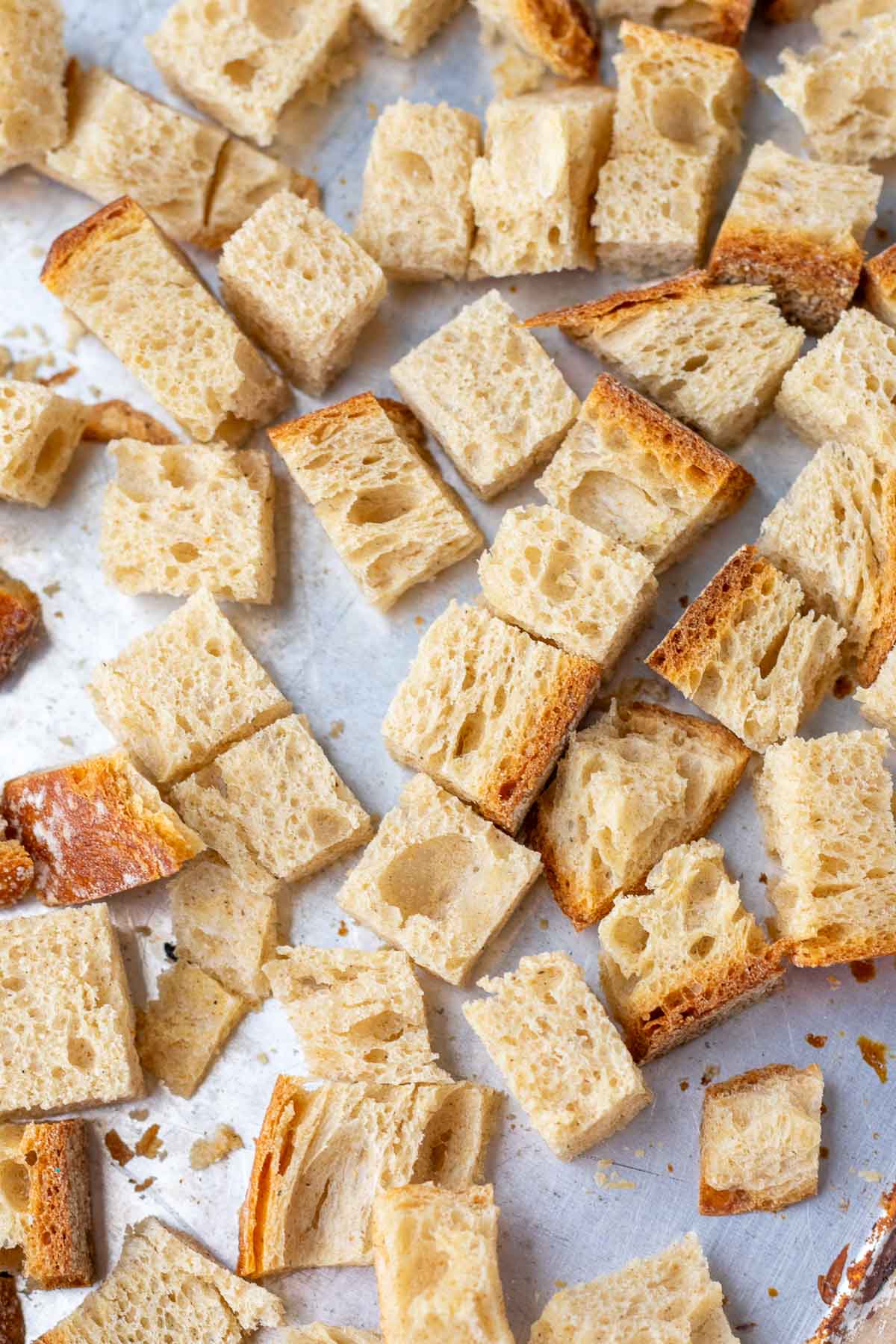 Close up of sourdough bread cubes on a sheet pan.