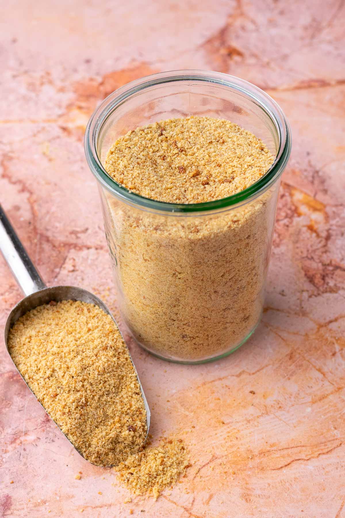 Jar of sourdough breadcrumbs with a scoop.