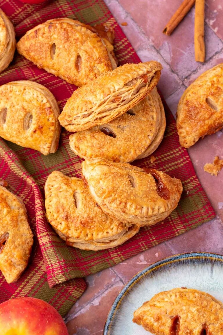 Flaky sourdough apple hand pies on a red and green plaid cloth.