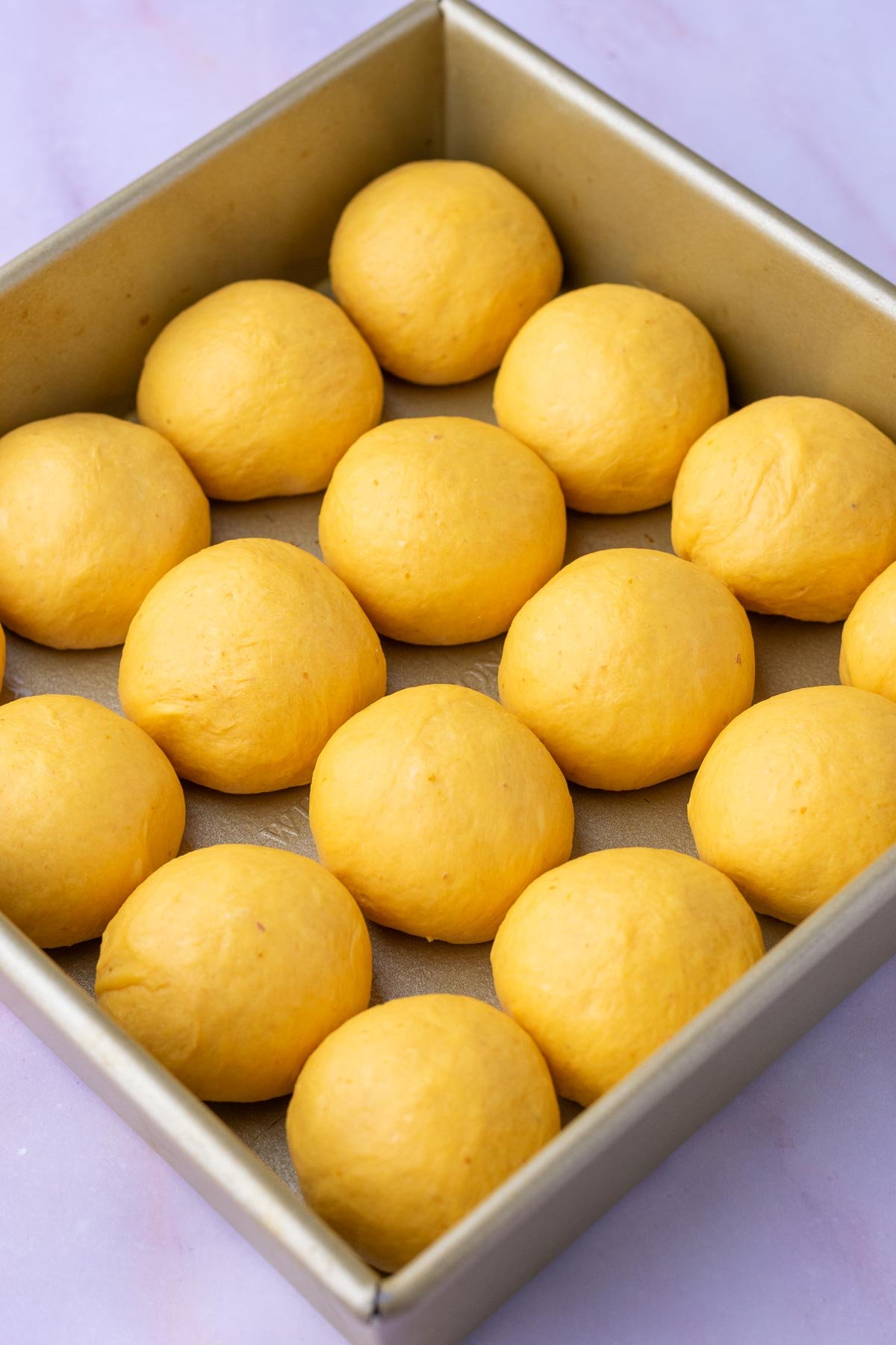 A pan of sourdough pumpkin dinner rolls at the start of final proofing.