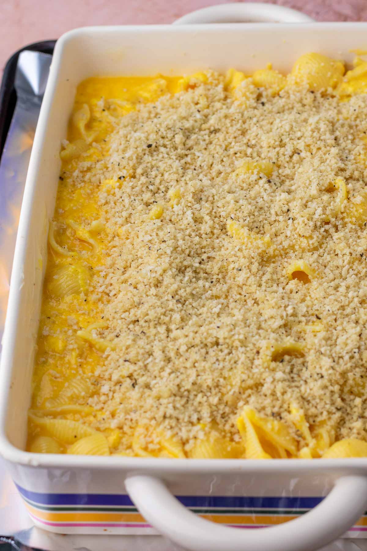 Baking dish with unbaked sourdough mac and cheese with sourdough breadcrumbs.
