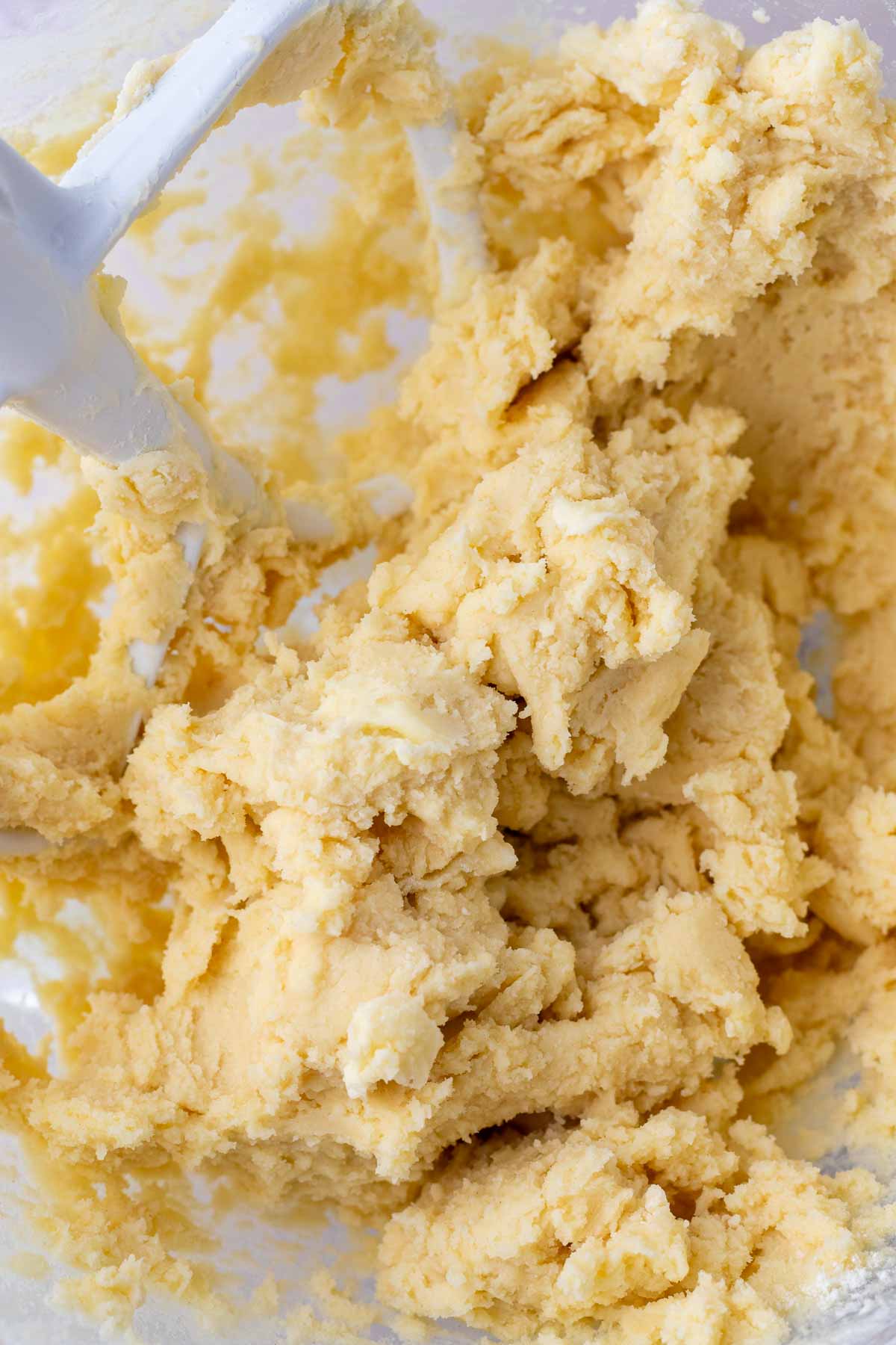 Mixed sourdough shortbread cookie dough in a stand mixer bowl.