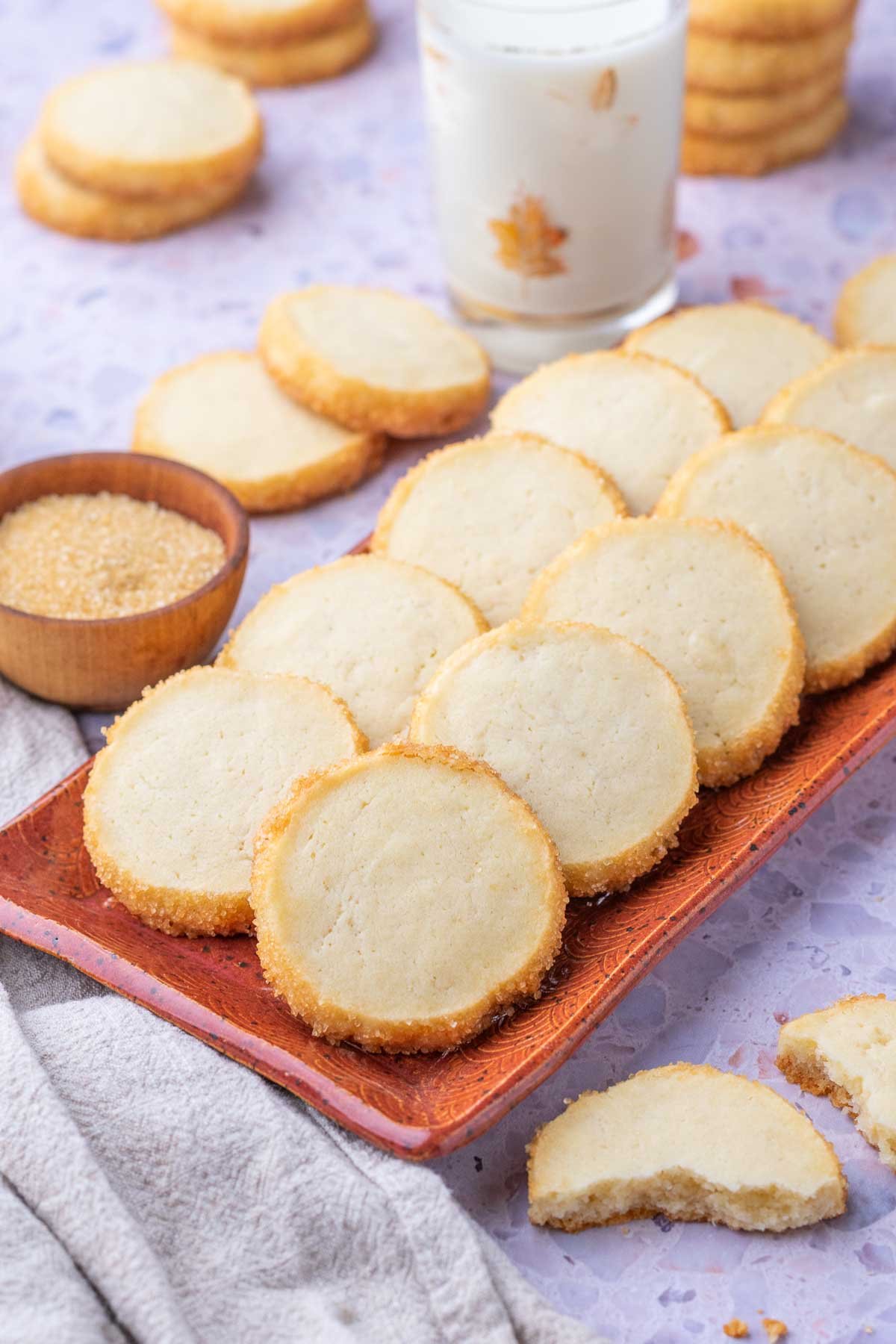 Plate of sourdough shortbread cookies with a glass of milk in the background.