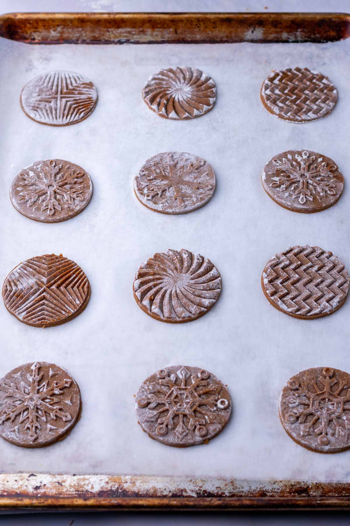 Unbaked soft glazed sourdough gingerbread cookies on a sheet pan.