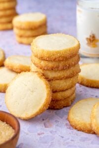 Stack of sourdough shortbread cookies with milk in the background.