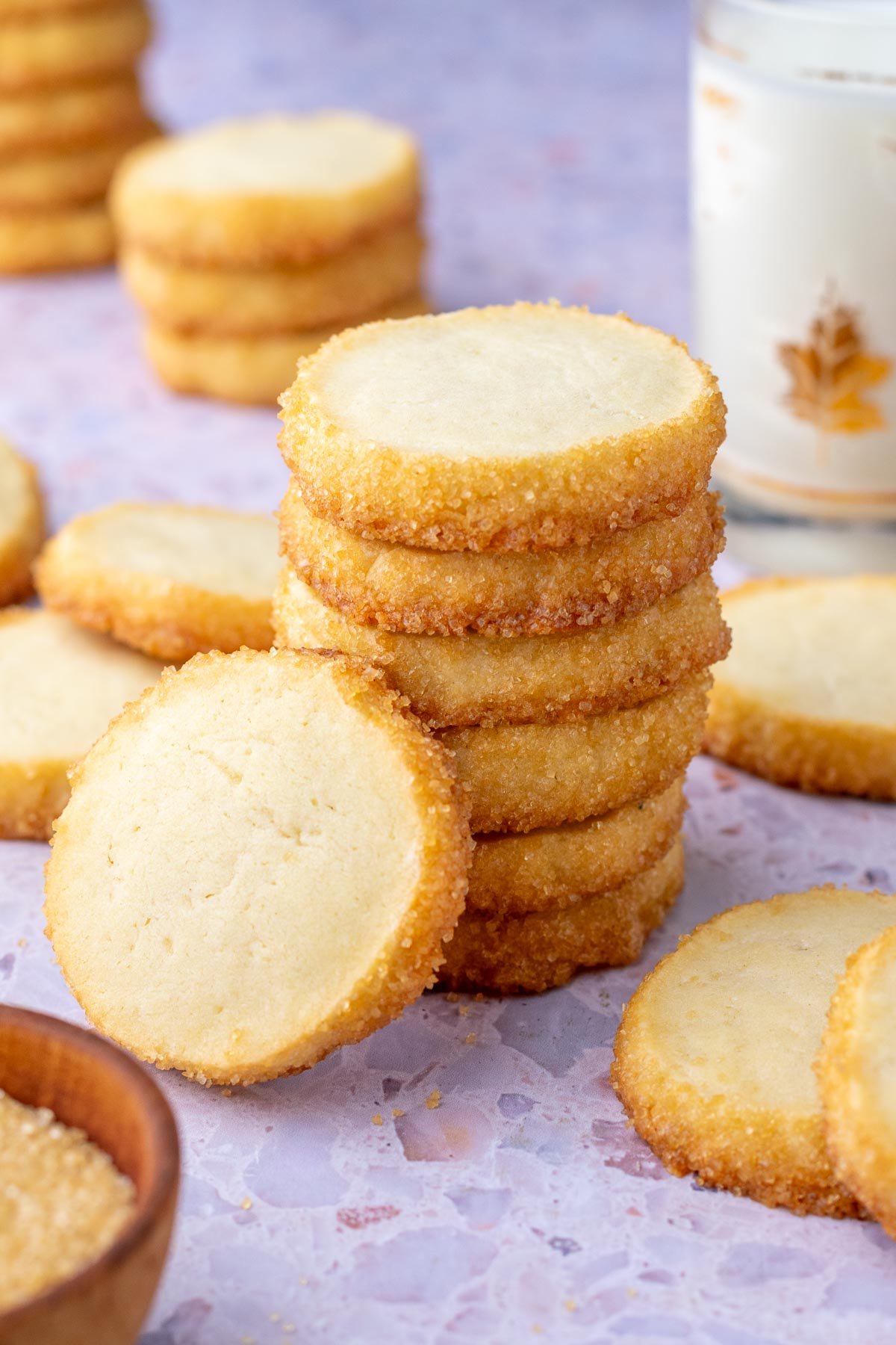 Stack of sourdough shortbread cookies with milk in the background.