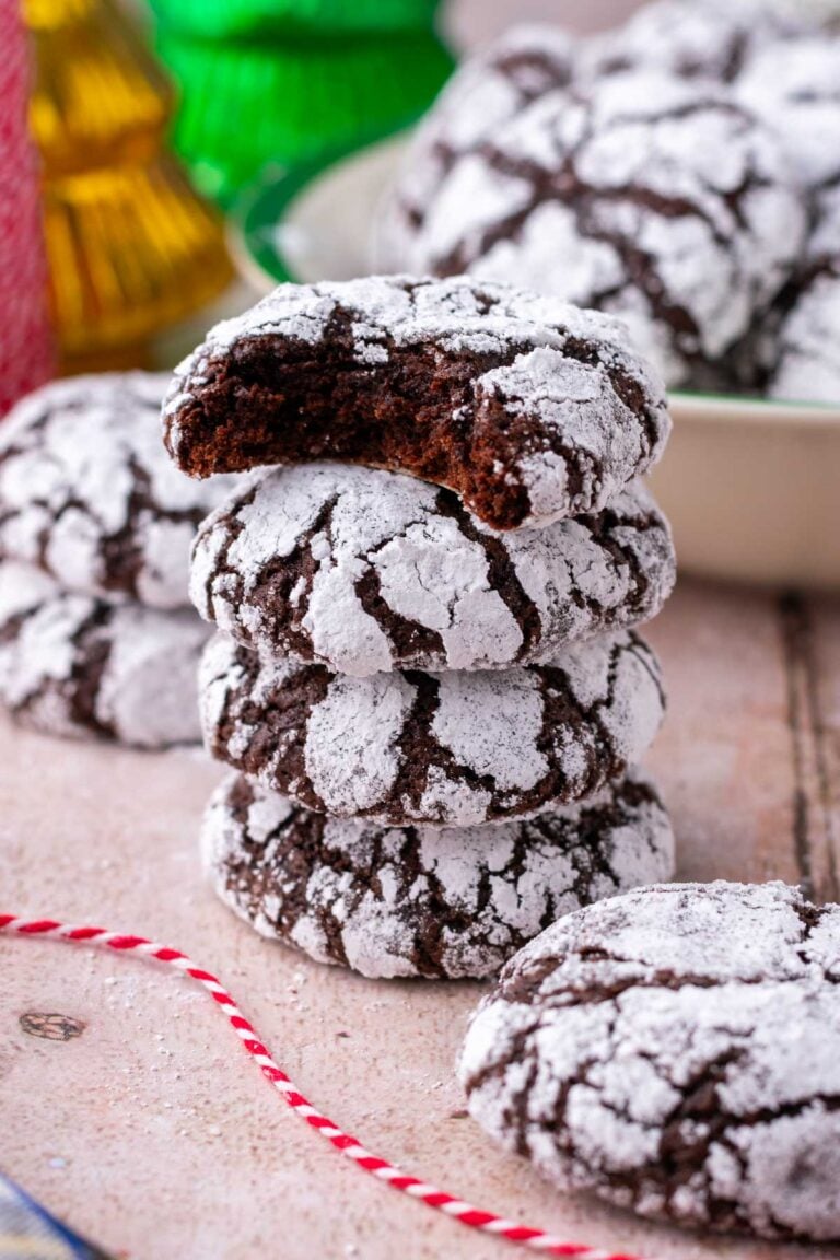 Stack of sourdough chocolate crinkle cookies with a bite out of the top cookie.