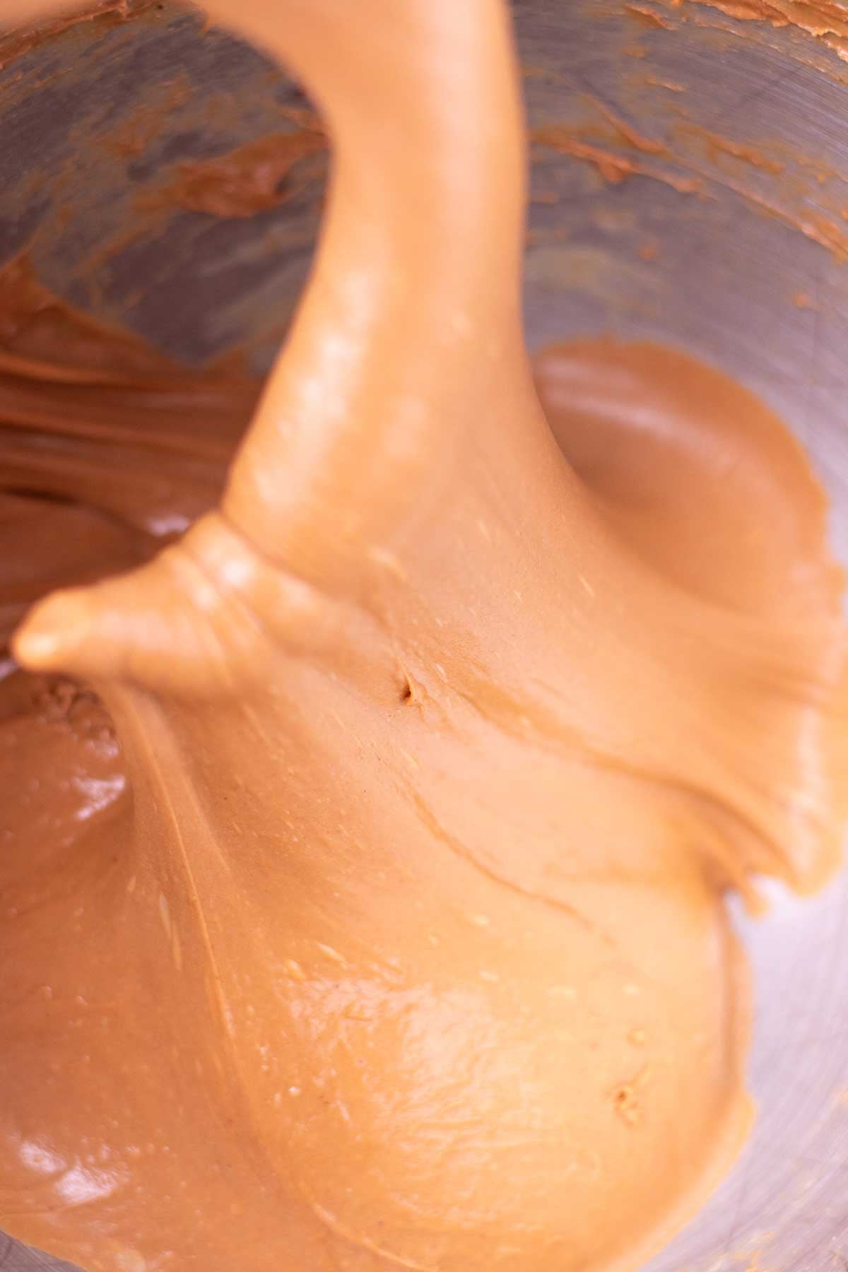 Mixed sourdough chocolate brioche dough in a stand mixer bowl that is silky and smooth.